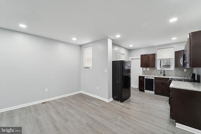 kitchen with sink, tasteful backsplash, dark brown cabinets, light hardwood / wood-style floors, and black appliances