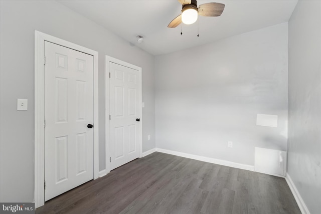 unfurnished bedroom with ceiling fan and dark hardwood / wood-style flooring