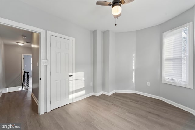 empty room with ceiling fan and light wood-type flooring