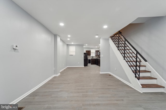 hall with sink and light wood-type flooring