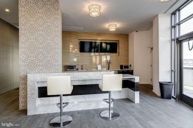 bar with hardwood / wood-style flooring and a wall of windows