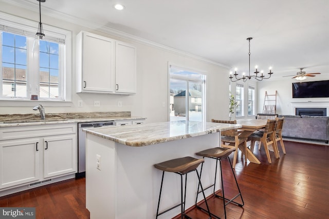 kitchen featuring white cabinetry, sink, pendant lighting, and stainless steel dishwasher