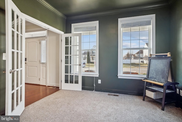 entryway featuring french doors, crown molding, and carpet