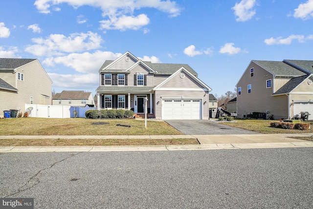 view of front of home with a porch, a garage, and a front yard