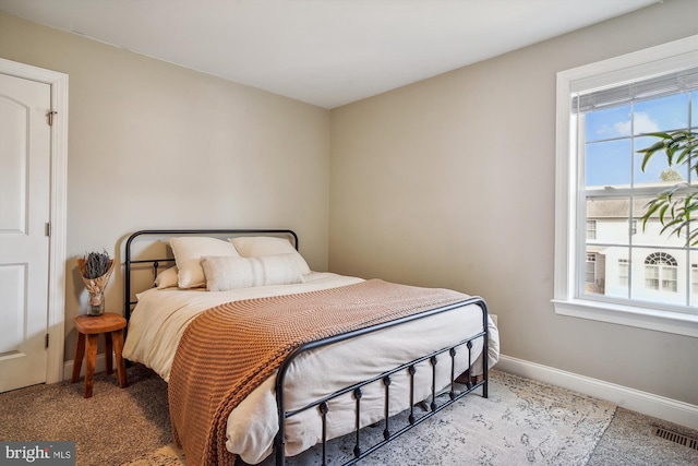 bedroom with light colored carpet and multiple windows