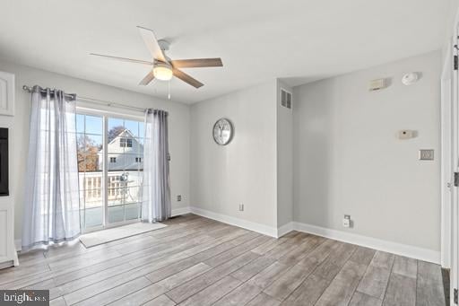 empty room with light wood-type flooring and ceiling fan