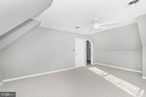 additional living space featuring ceiling fan, lofted ceiling, and carpet flooring