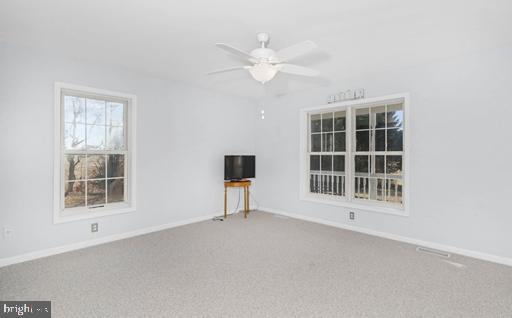 unfurnished room featuring ceiling fan and carpet