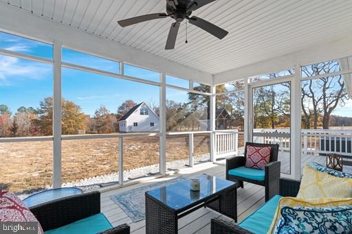 sunroom / solarium featuring a wealth of natural light and ceiling fan