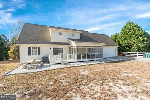 back of house featuring a garage, a sunroom, and central air condition unit