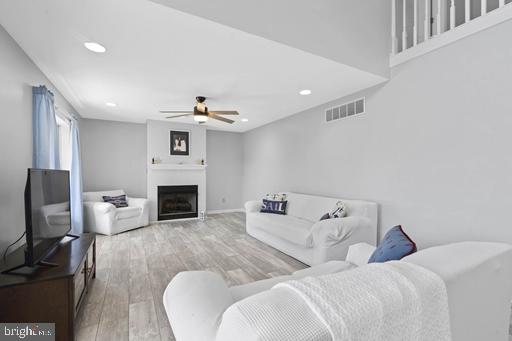 living room featuring hardwood / wood-style floors and ceiling fan