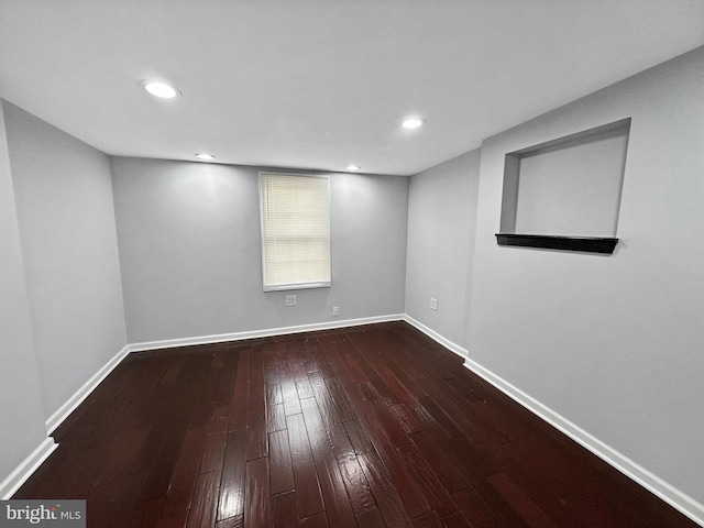 unfurnished room with dark wood-type flooring