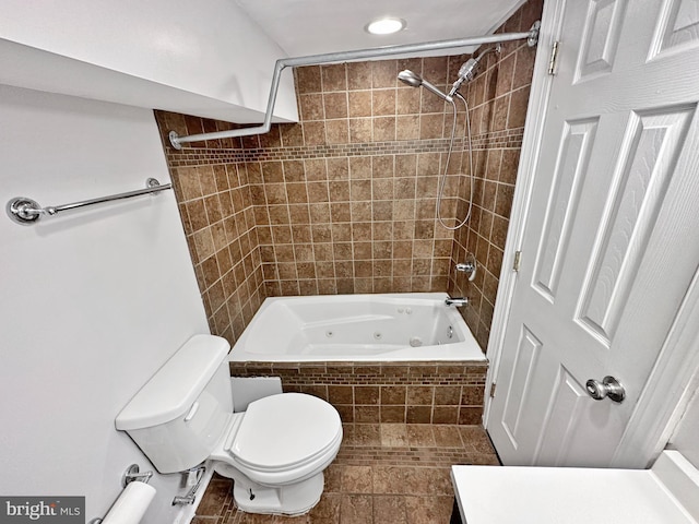 bathroom featuring toilet and tiled shower / bath