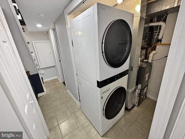 clothes washing area with stacked washer and dryer and light tile patterned floors