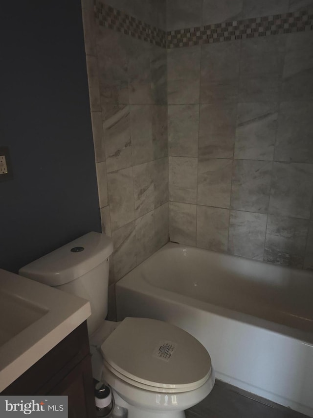 full bathroom featuring tiled shower / bath combo, vanity, and toilet