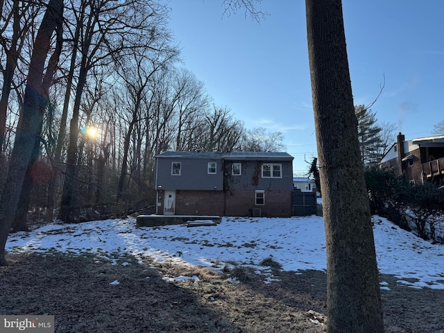 view of snow covered rear of property