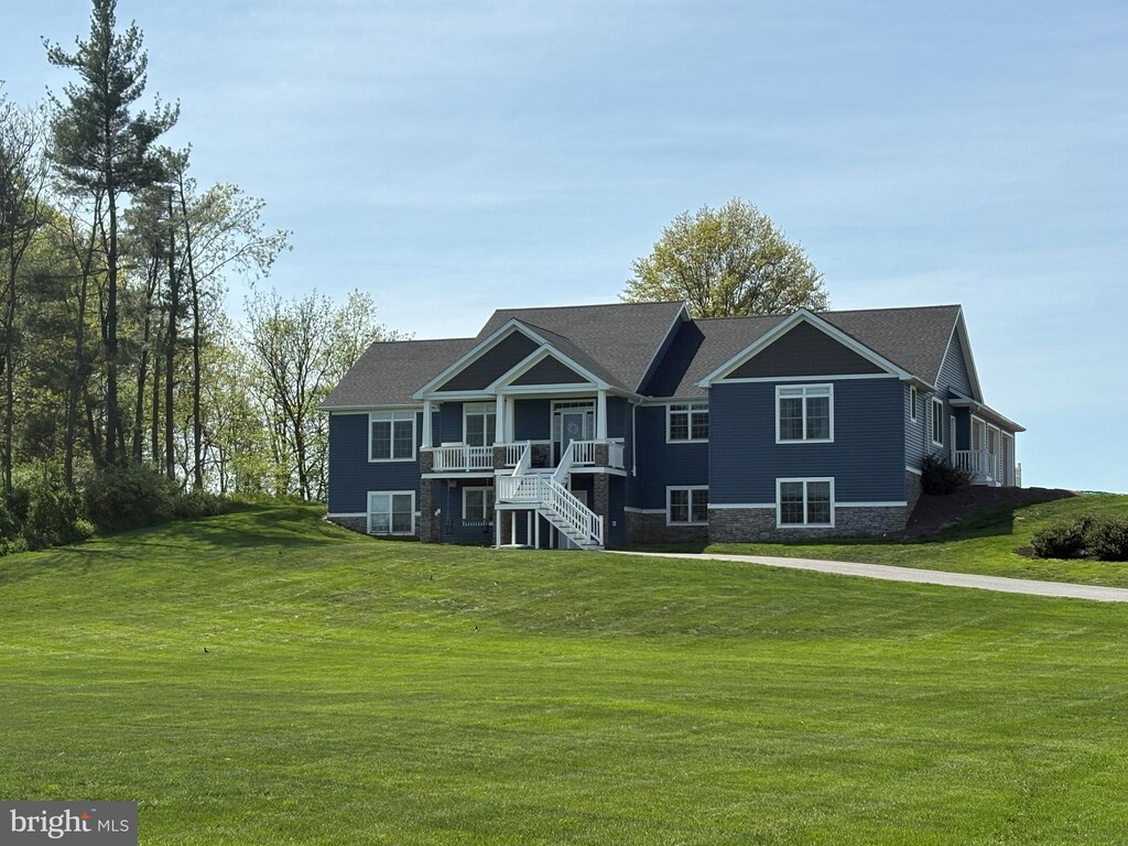 view of front of property with stairway, a front yard, and a deck