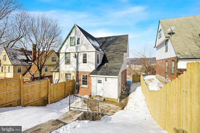 view of snow covered rear of property