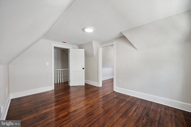 bonus room with dark hardwood / wood-style flooring and vaulted ceiling