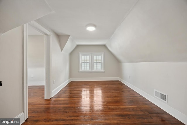 bonus room with lofted ceiling and dark hardwood / wood-style floors