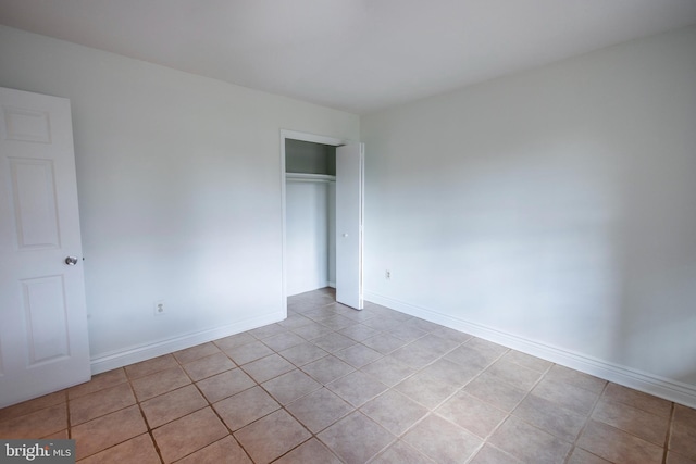 unfurnished bedroom with a closet and baseboards