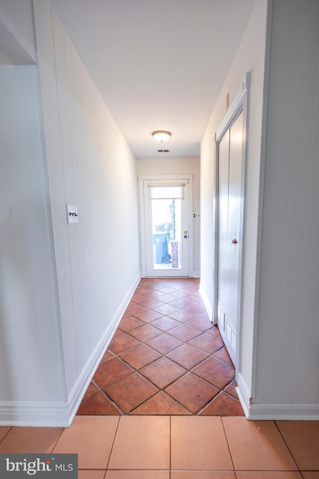 hall featuring tile patterned floors and baseboards