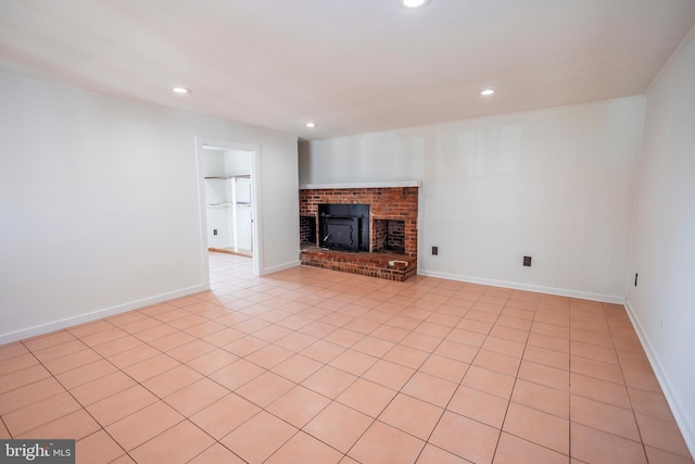 unfurnished living room featuring a brick fireplace, recessed lighting, and baseboards