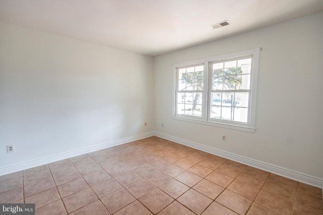 unfurnished room with baseboards and visible vents