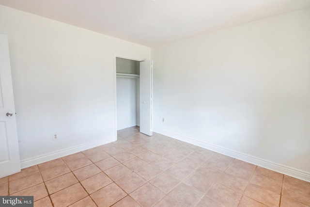 unfurnished bedroom with baseboards and a closet