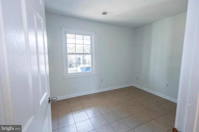 unfurnished room featuring light tile patterned floors, visible vents, and baseboards