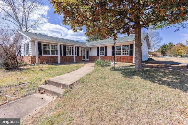 ranch-style house with brick siding and a front yard