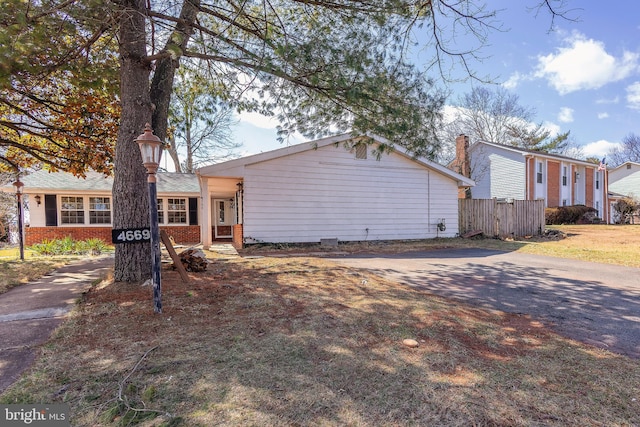 view of front of house with fence and brick siding