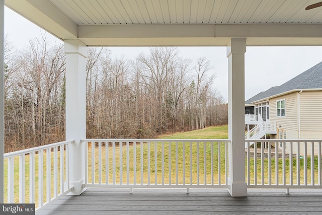 wooden deck featuring a lawn