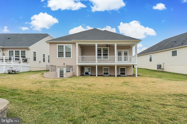 back of property with cooling unit, ceiling fan, and a lawn