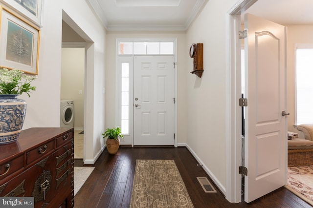 foyer entrance featuring dark hardwood / wood-style flooring, washer / clothes dryer, and crown molding