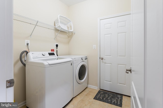 washroom featuring washing machine and dryer and light tile patterned flooring