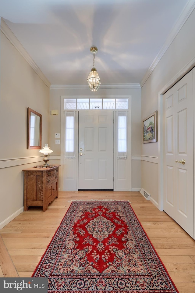 foyer featuring light hardwood / wood-style flooring and ornamental molding