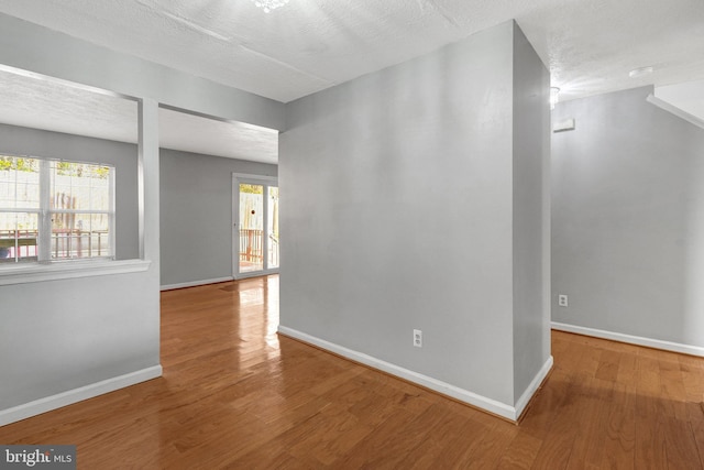 empty room featuring wood finished floors and baseboards