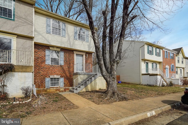 view of front of property with brick siding and stairway