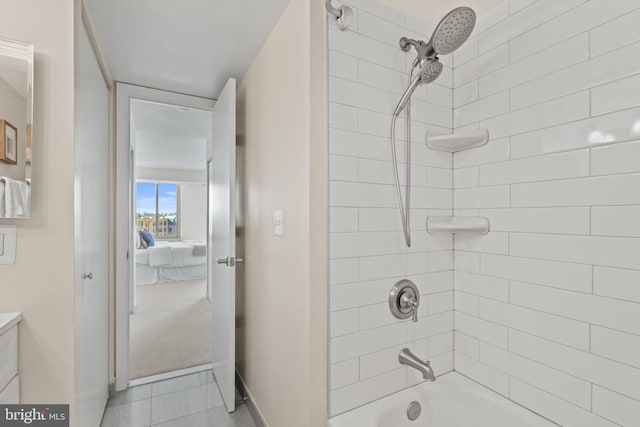 bathroom featuring tiled shower / bath combo and vanity