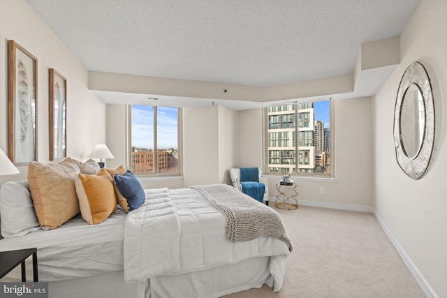 carpeted bedroom featuring multiple windows and a textured ceiling