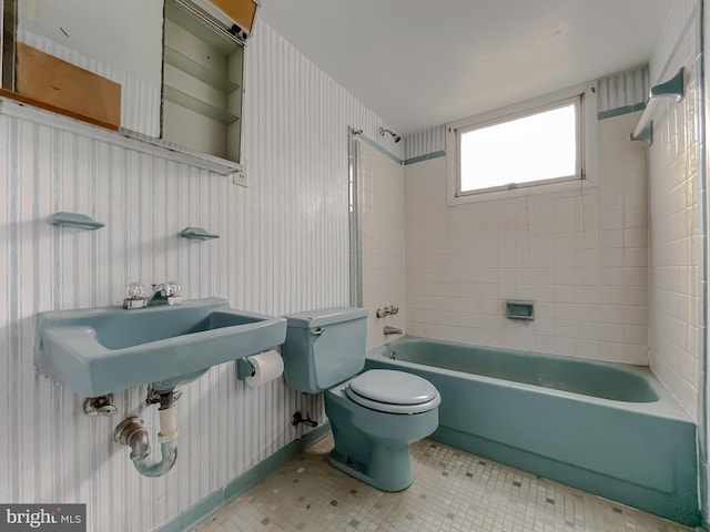 bathroom with toilet and tiled shower / bath combo