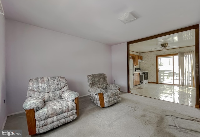 living area with light colored carpet and ceiling fan