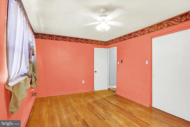 empty room with ceiling fan and light hardwood / wood-style flooring