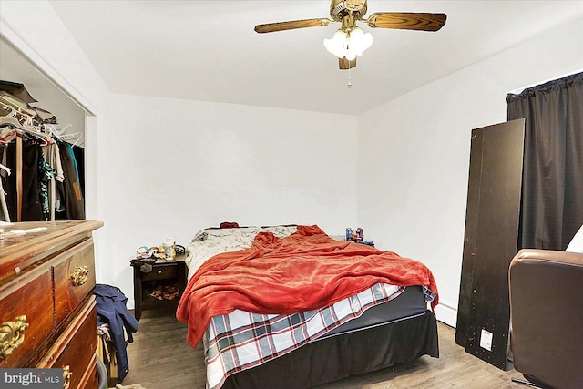 bedroom featuring baseboard heating, ceiling fan, light hardwood / wood-style floors, and a closet