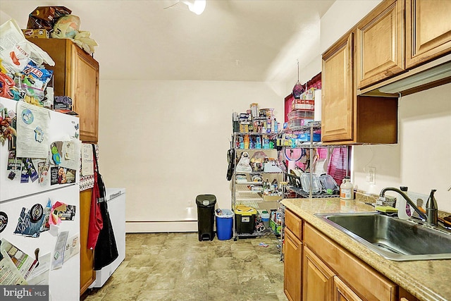 kitchen featuring sink, baseboard heating, and white fridge