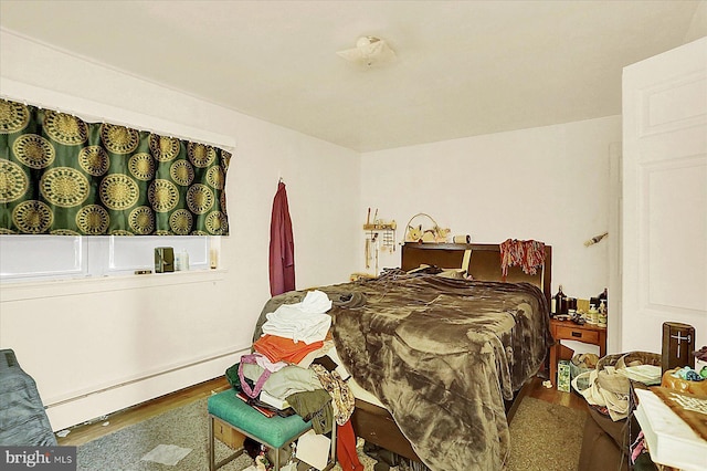 bedroom with hardwood / wood-style flooring and a baseboard radiator