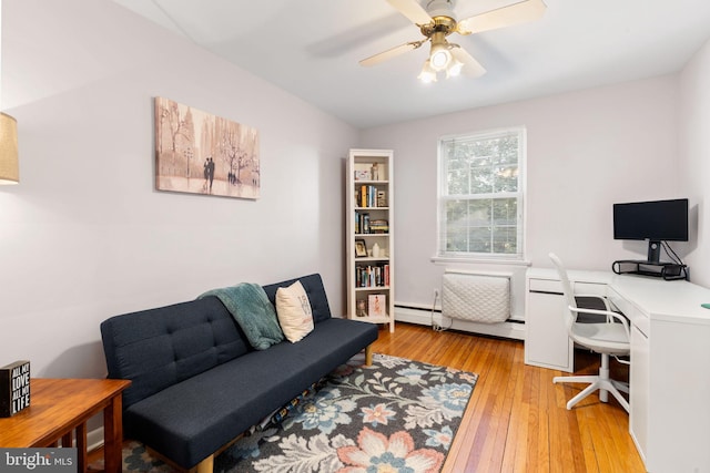 office with ceiling fan, a baseboard radiator, and light wood-type flooring