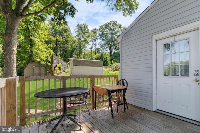 wooden deck featuring a lawn and a storage unit