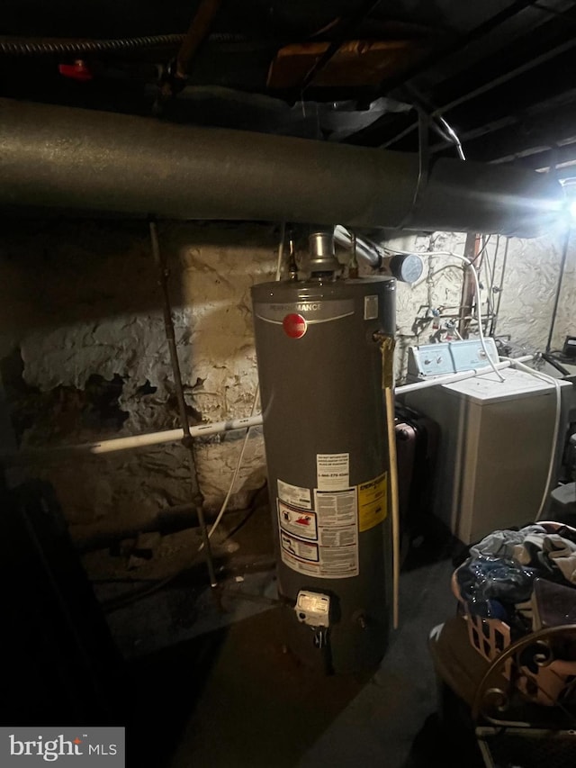 utility room with water heater and washer and clothes dryer